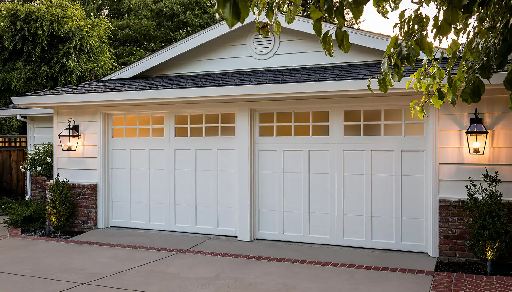 White insulated Coachman carriage house garage doors with windows on a Puget Sound style home